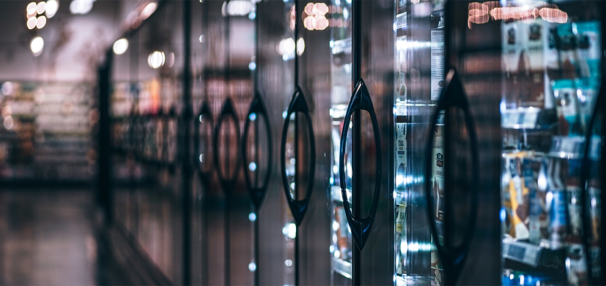 Commercial reach-in cooler doors in a grocery aisle